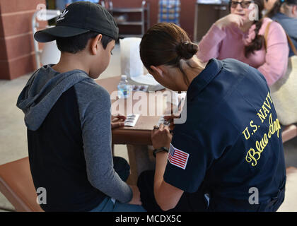 180225-N-ZC358-086  EL CENTRO, Calif. (Feb. 25, 2018) Aviation Machinist Mate 2nd Class, Morgan Alvarez, autographs photos at El Centro Regional Medical Hospital during a meet and greet event. The Blue Angels are scheduled to perform more than 60 demonstrations at more than 30 locations across the U.S. in 2018. (U.S. Navy photo by Mass Communication Specialist 2nd Class Jess Gray/Released) Stock Photo