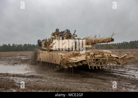 An M1 Abrams Tank with mine plow attachment conducts fire and maneuver training operations with 2d Tank Batttalion, 2d Marine Division, aboard Fort Stewart, Ga., Feb. 10, 2018. This exercise ensures the unit can effectively employ their tanks in combat scenarios as well as provide support for adjacent units. (U.S. Marine Corps photo by Cpl. Alexander Sturdivant) Stock Photo