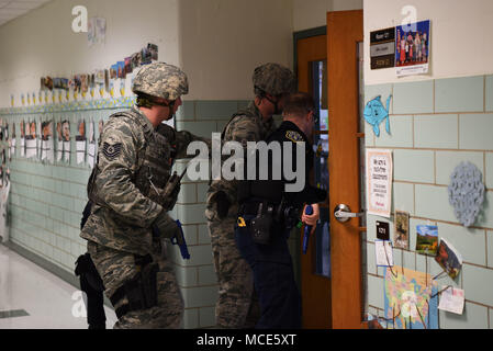 From the left, Tech. Sgt. Adam Paini, 436th Security Forces Squadron, Staff Sgt. Brandon Trapp, 436th SFS, and Officer Justin Viens, 436th SFS supervisory police officer, clear rooms during an active shooter exercise Feb. 26, 2018, at the George S. Welch Elementary School and Dover Air Force Base Middle School at Dover AFB, Del. The 436th Inspector General office evaluated school faculty and Security Forces on their response procedures. (U.S. Air Force photo by Airman 1st Class Zoe M. Wockenfuss) Stock Photo