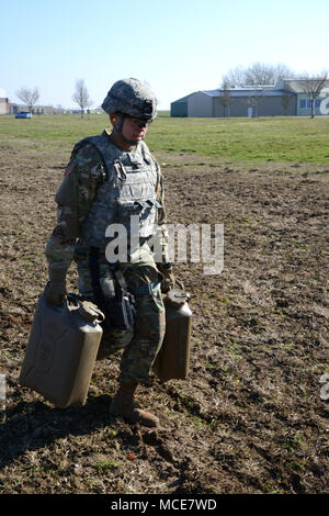 U.S. Army Spc. Jacqueline Delgado, assigned to U.S. Army Garrison Benelux, carries two full jerrycans on 25 meter long during the Best Warrior Competition, in Chièvres Air Base, Belgium, Feb.22, 2018. (U.S. Army photo by Visual Information Specialist Pascal Demeuldre) Stock Photo