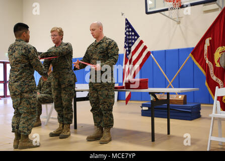 Lieutenant Col. Karin Fitzgerald, the commanding officer for Special Purpose Marine Air-Ground Task Force-Crisis Response-Africa, logistics combat element, presents a certificate of completion to a Marine during a joint Corporals Course graduation ceremony at Naval Air Station Sigonella, Italy, Feb. 16, 2018. Marines, Sailors and an Airman participated in the course that consist of classes on land navigation, sword and guidon manual, fire team and squad formations and developing mentorship and leadership skills. SPMAGTF-CR-AF is deployed to conduct crisis-response and theater-security operatio Stock Photo