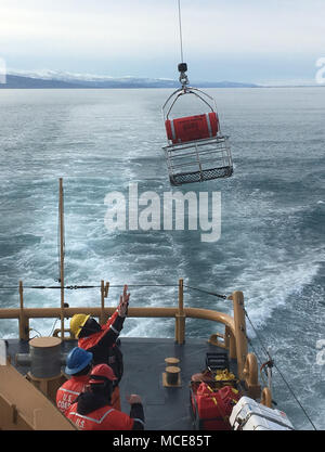 Coast Guard Cutter Naushon (WPB 1311) and crew conduct hoist training with an Air Station Kodiak MH-65 Dolphin helicopter crew in Kachemak Bay near Homer, Alaska, Feb. 21, 2018. Hoist training ensures both the boat crew and aircrew are proficient in these skills when search and rescue calls arrive. U.S. Coast Guard photo. Stock Photo