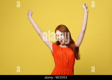 Lifestlye, freedom and happiness concept - Portrait Young beautiful happy  girl in orange gorgeous dress showing hand in air. Iso Stock Photo - Alamy