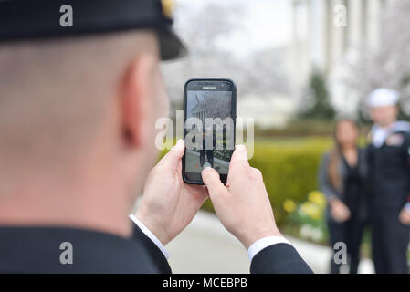 180411-N-YU482-046 WASHINGTON (April 11, 2018) Navy Reserve Force Master Chief Chris Kotz takes a photo of Master-at-Arms 1st Class Ian Barton, a finalist for the Navy Reserve Sailor of the Year and his wife in front of the Supreme Court during a tour of Washington D.C. as part of a week-long schedule of events and ceremony to select the top Reserve Sailor and recognize each of the four finalists for their exceptional performance. (U.S. Navy photo by Chief Mass Communication Specialist Stephen Hickok/Released) Stock Photo