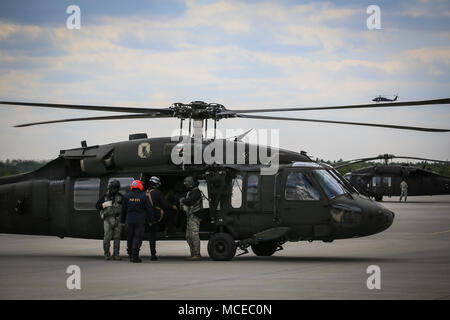 New Jersey Air National Guard Airmen and members of New Jersey Task Force One board a UH-60L Black Hawk helicopter from Det. 2 , C Company, 1-171st Aviation for helicopter rescue basket training over Joint Base McGuire-Dix-Lakehurst, N.J., April 11, 2018. The New Jersey National Guard trained with New Jersey Task Force One, an urban search and rescue unit. (U.S. Air National Guard photo by Master Sgt. Matt Hecht) Stock Photo