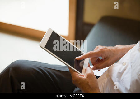 Senior man hands using tablet PC Stock Photo