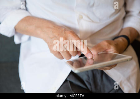Senior man hands using tablet PC Stock Photo