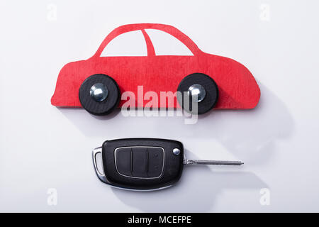 Close-up Of Red Car And Key On White Background Stock Photo