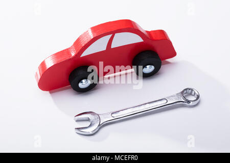 Elevated View Of Red Car And Wrench Isolated On White Background Stock Photo