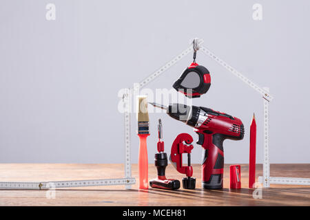 Close-up Of Repairs Tools Under The House Made With Measuring Tape On The Wooden Table Stock Photo