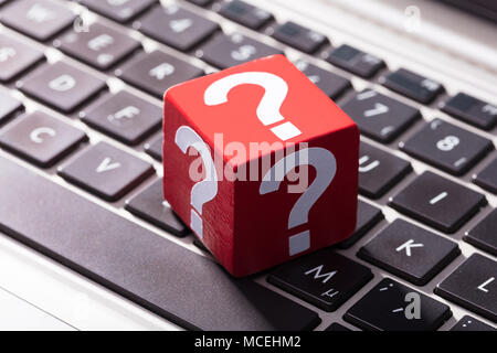 Close-up Of Question Mark Symbols On Red Block Over The Laptop Keypad Stock Photo