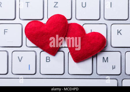 Elevated View Of Soft Two Red Hearts Shape On Keyboard Stock Photo
