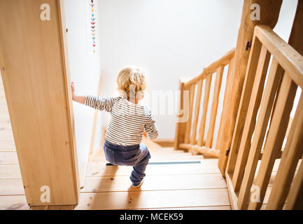 Toddler boy in dangerous situation at home. Child safety concept. Stock Photo