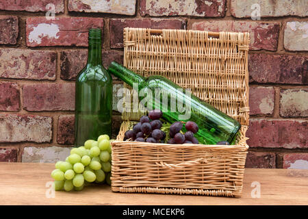 Still life. Basket of grapes and empty wine bottles. Stock Photo