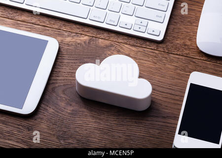 White Cloud Block With Digital Tablet, Mobile, Keyboard And Mouse On The Wooden Table Stock Photo