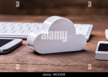 White Cloud Block With Digital Tablet, Mobile, Keyboard And Mouse On The Wooden Table Stock Photo