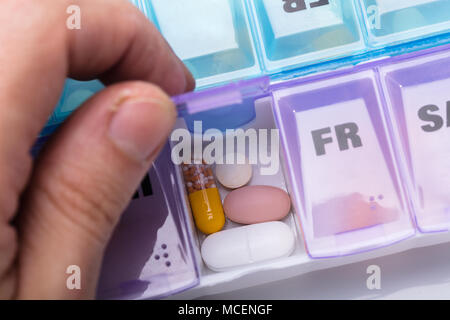 Close-up Of A Person's Hand Taking Prescription Medicine From Organizing Pill Box Stock Photo