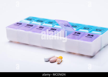 Pink Plastic Pill Organizer Shot And Medical Pills On White Background Stock Photo