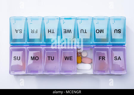 Pink Plastic Pill Organizer Shot And Medical Pills On White Background Stock Photo