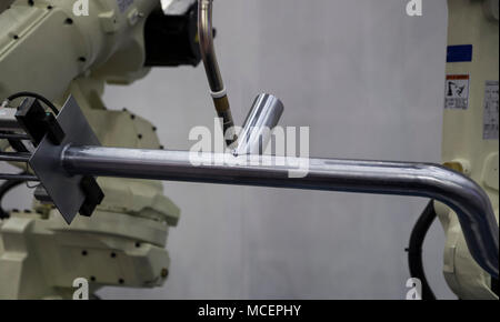 Robot arm welding pipe ; focus at torch Stock Photo
