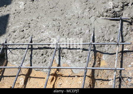 Wet concrete is poured into wire mesh steel rod Stock Photo