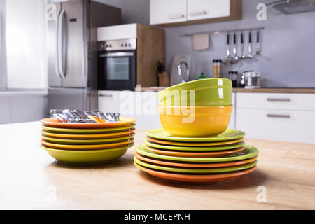 Close-up Of Stacked Plates And Bowls On Wooden Desk Stock Photo