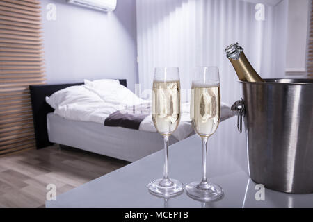 Close-up Of Two Champagne Glasses On Table In Bedroom Stock Photo
