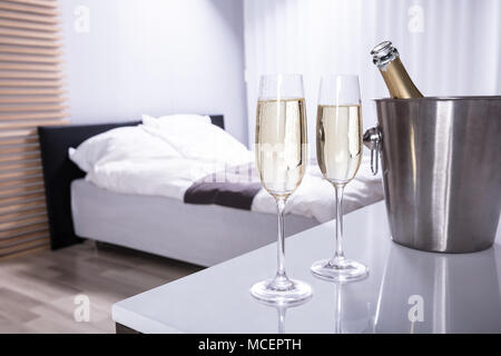 Close-up Of Two Champagne Glasses On Table In Bedroom Stock Photo