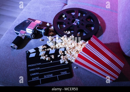 High Angle View Of Spilled Popcorn With Clapperboard And Movie Camera At Night Stock Photo