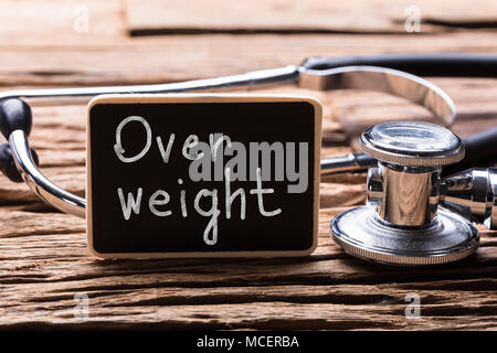 Close-up Of Stethoscope With Slate Showing Overweight Text On Wooden Desk Stock Photo