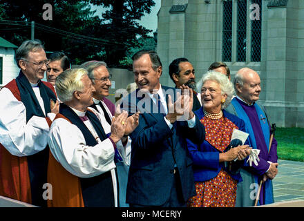 Washington, DC., USA, September 29, 1990 President George H.W. Bush and First Lady Barbara Bush at the dedication ceremony of the National Cathedral. At noon on September 29th, 1990, the last stone for the National Cathedral in Washington, DC, was raised and set on the Saint Paul Tower. The stone was a 1,008 pound piece of carved Indiana limestone, cut in Ellettsville, Indiana, at the Bybee Stone Company, where the final two front entrance towers had been fabricated. Stock Photo