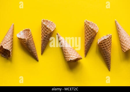 Empty waffle wafer ice cream cone on a bright yellow background Stock Photo