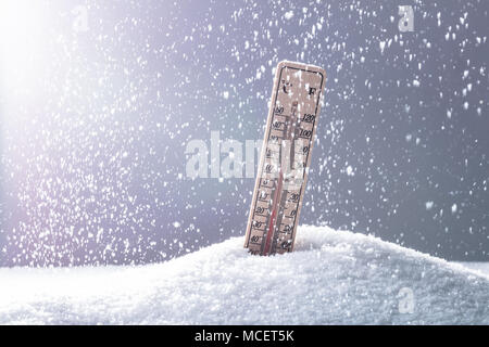 Thermometer On Snow Showing Low Temperature In Heavy Snowfall Stock Photo
