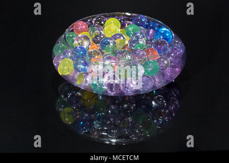 Bowl with colored hydrogel balls, on black background Stock Photo
