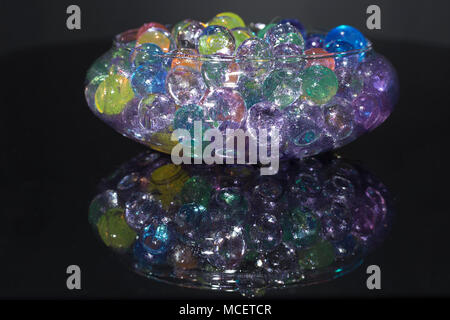 Bowl with colored hydrogel balls, on black background Stock Photo