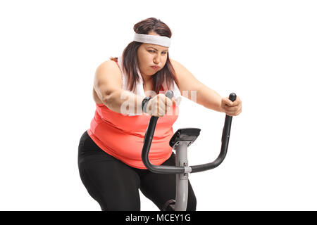 Exhausted overweight woman exercising on a stationary bike isolated on white background Stock Photo