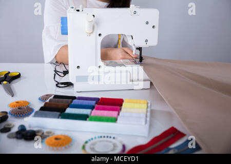 Fashion Designer Working On Sewing Machine Stitching A Long Length Fabric Stock Photo