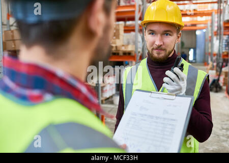 Young Worker Talking to Supervisor in  Warehouse Stock Photo