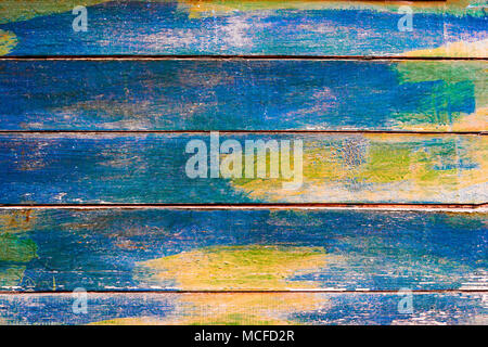 Painted in blue with spots of yellow weathered planks of fence. Stock Photo