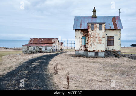 Near Garður on the Reyjanes peninsula, Iceland. Old corrugated iron buildings at an abandoned farm on the coast. Stock Photo