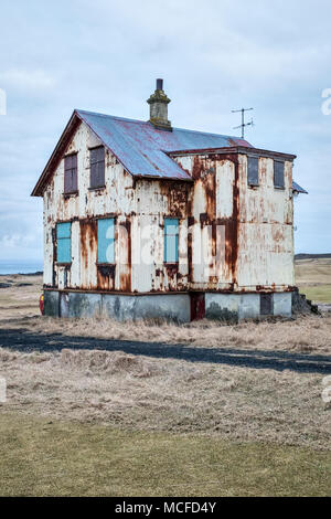 Near Garður on the Reyjanes peninsula, Iceland. Old corrugated iron buildings at an abandoned farm on the coast. Stock Photo