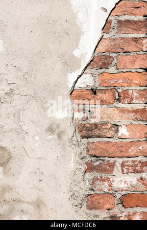 Old plastered wall with red bricks Stock Photo
