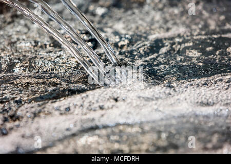 Jet of blue clear water with bubbles Stock Photo