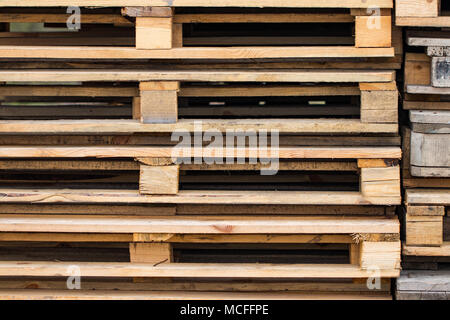 Stacks of Wooden pallets for industrial transportation by trucks. Stock Photo