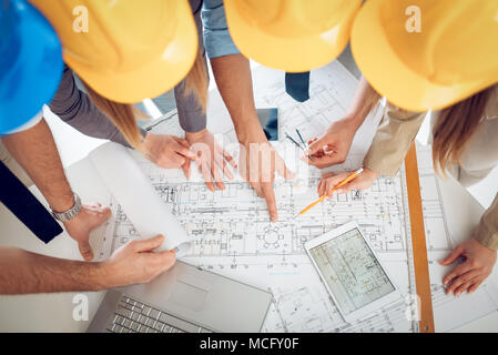 Young architect team discussing construction plans and planning what to change to be better. Top view. Stock Photo