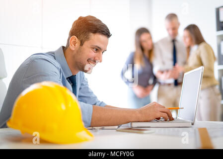 Young arabian male constructor working at laptop in the office. Selective focus. Stock Photo