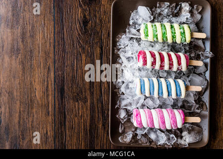 Popsicles ice cream with ice on dark surface. Summer Dessert Concept. Stock Photo