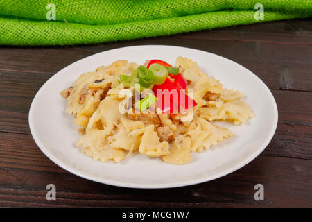 Wholemeal pasta baked with cabbage on a wooden table Stock Photo