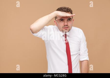 Businessman look far away. Business people concept, good and bad emotion and feelings. Studio shot, isolated on light brown background Stock Photo