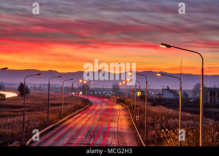 Speed Traffic - light trails on motorway highway at sunset Stock Photo